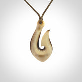 A fish hook necklace (hei-matau) hand-carved in a traditional style from Woolly Mammoth Tusk. These are glorious pieces of art to wear. Provided with adjustable cords and packaged in a woven kete pouch. Delivered with express courier.